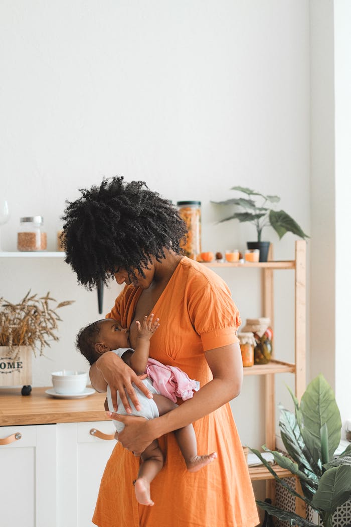 A loving mother gently holding her baby in a bright, cozy kitchen.