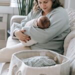 A tender moment of motherhood as a mother cradles her newborn baby indoors in a cozy living room setting.
